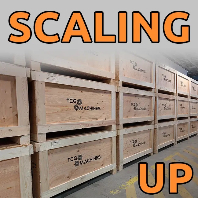 The words "Scaling Up" are superimposed over stacks of TCG Machines shipping crates stretching into the distance
